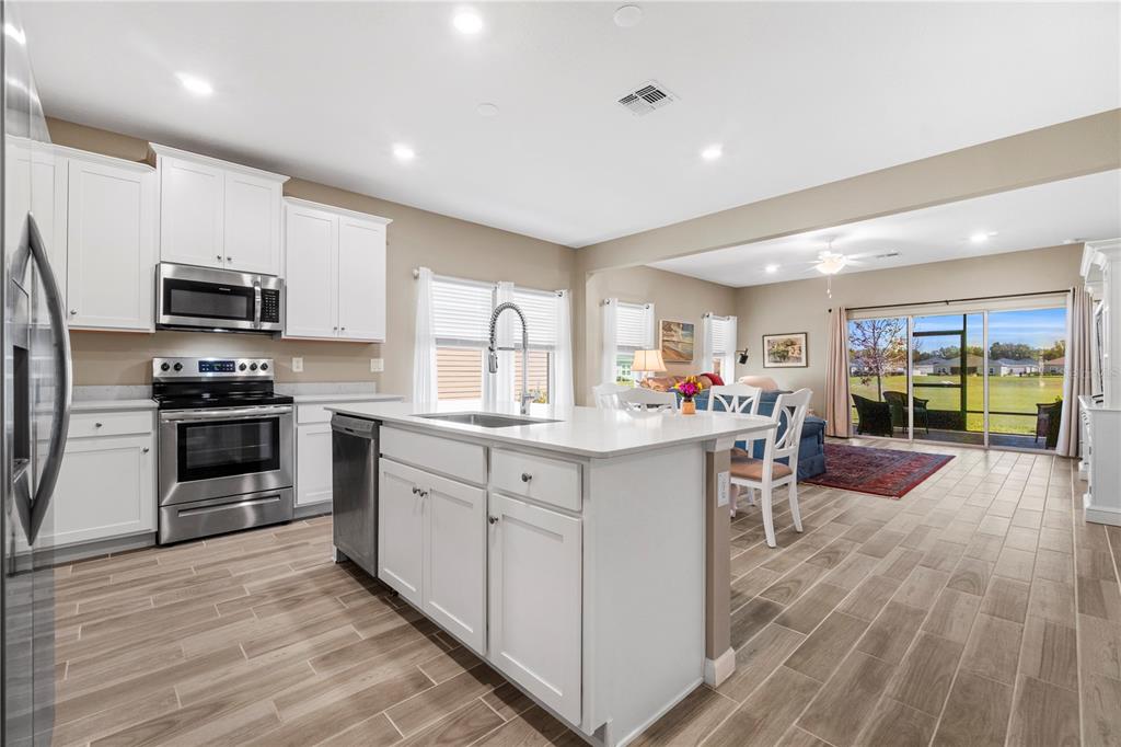 7381 Southwest 78th Terrace Ocala, FL 34474 - Photo 9 of 47 a kitchen with stainless steel appliances a stove a sink a oven a dining table and chairs