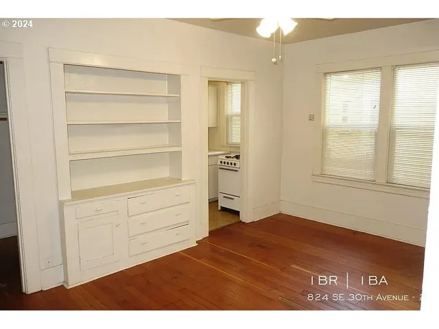 an empty room with a potted plant and wooden floor