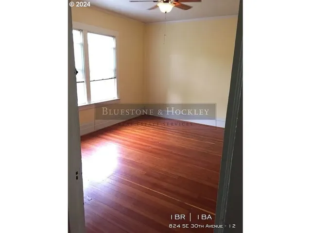 a view of a room with wooden floor and a window