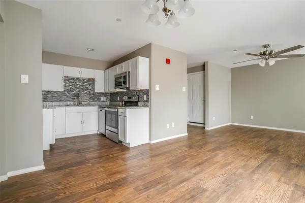 a kitchen with granite countertop a stove cabinets and wooden floor