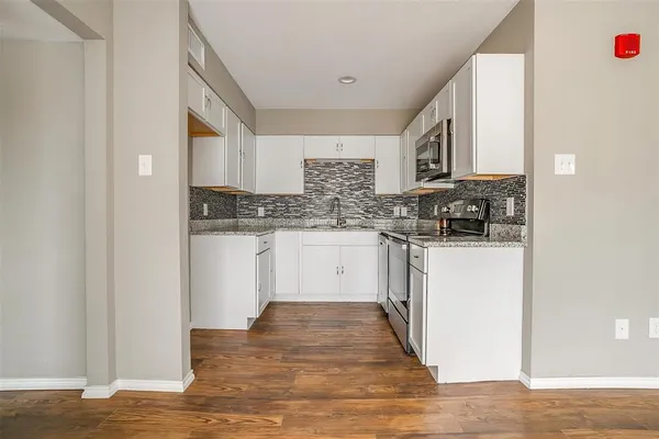 a kitchen with stainless steel appliances granite countertop a stove and a refrigerator