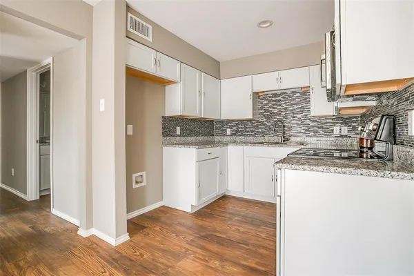a kitchen with granite countertop a sink and a stove top oven