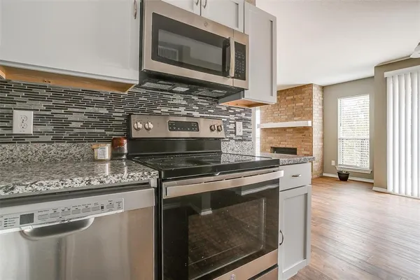 a kitchen with stainless steel appliances wooden cabinets stove and microwave