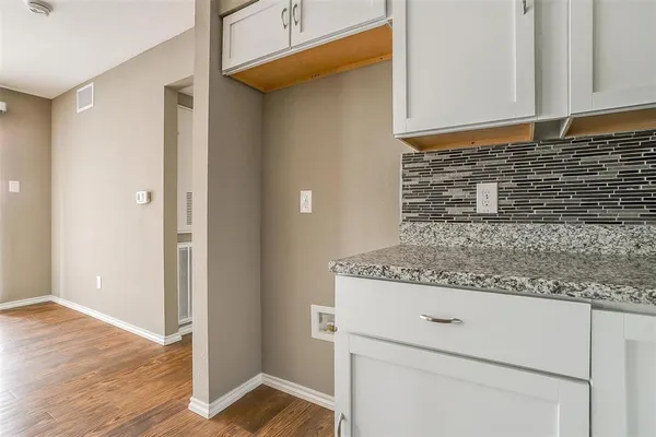a view of granite countertop cabinets and a wooden floor