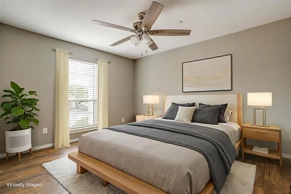 a bedroom with a large bed and a potted plant