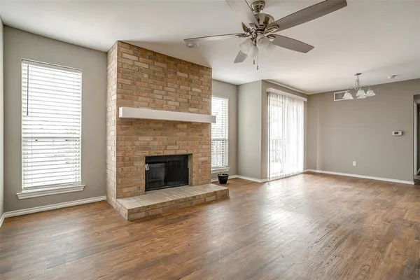 wooden floor fireplace and windows in an empty room