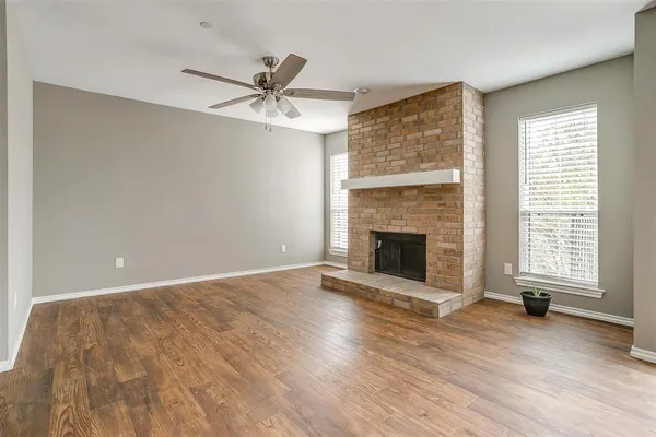 a view of an empty room with a fireplace and a window