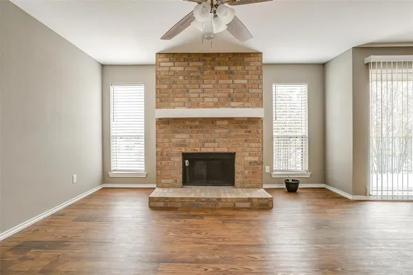 wooden floor fireplace and windows in an empty room