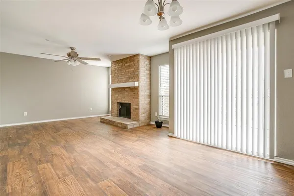 an empty room with windows and a fireplace