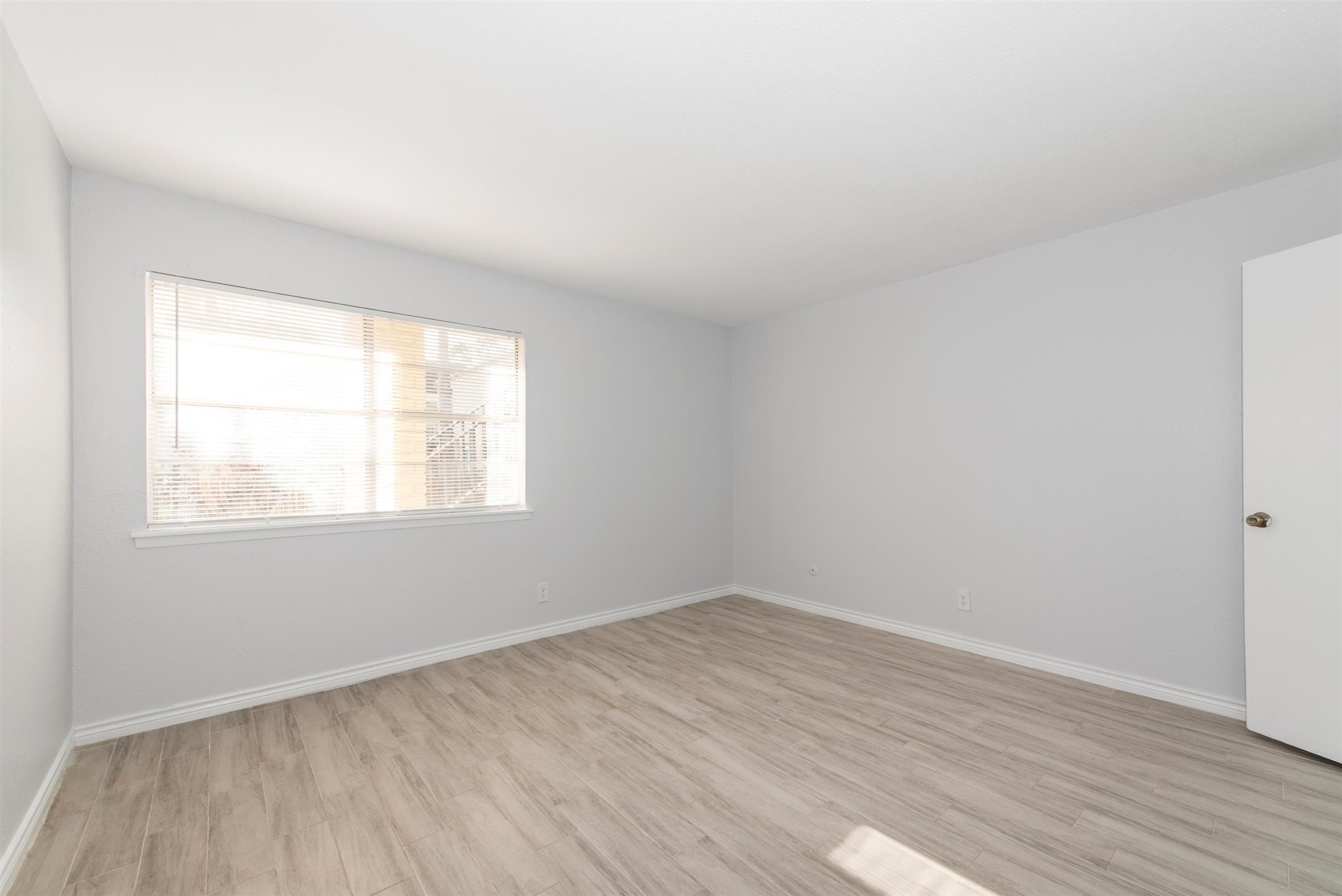6200 West Tidwell Road, Unit 1613 Houston, TX 77092 - Photo 5 of 16 an empty room with wooden floor and windows