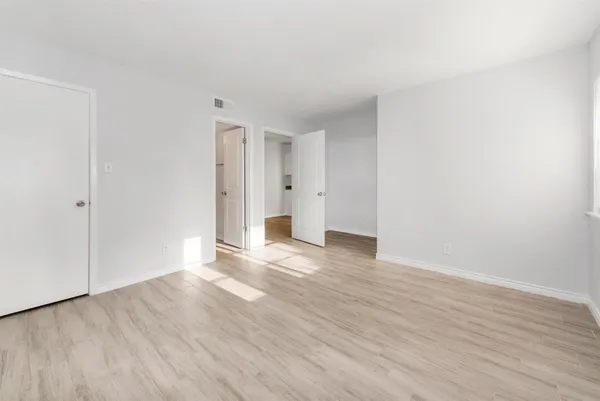 a view of an empty room with wooden floor