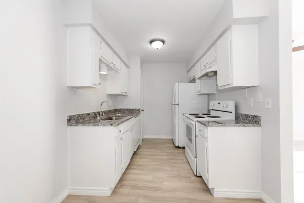 a kitchen with stainless steel appliances a sink stove and cabinets