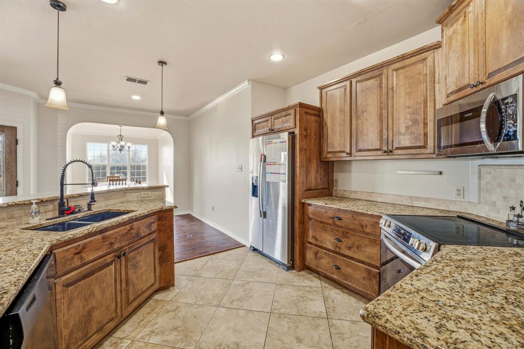 1114 Elk Ridge Drive Stephenville, TX 76401 - Photo 11 of 32 a kitchen with stainless steel appliances granite countertop a sink and cabinets