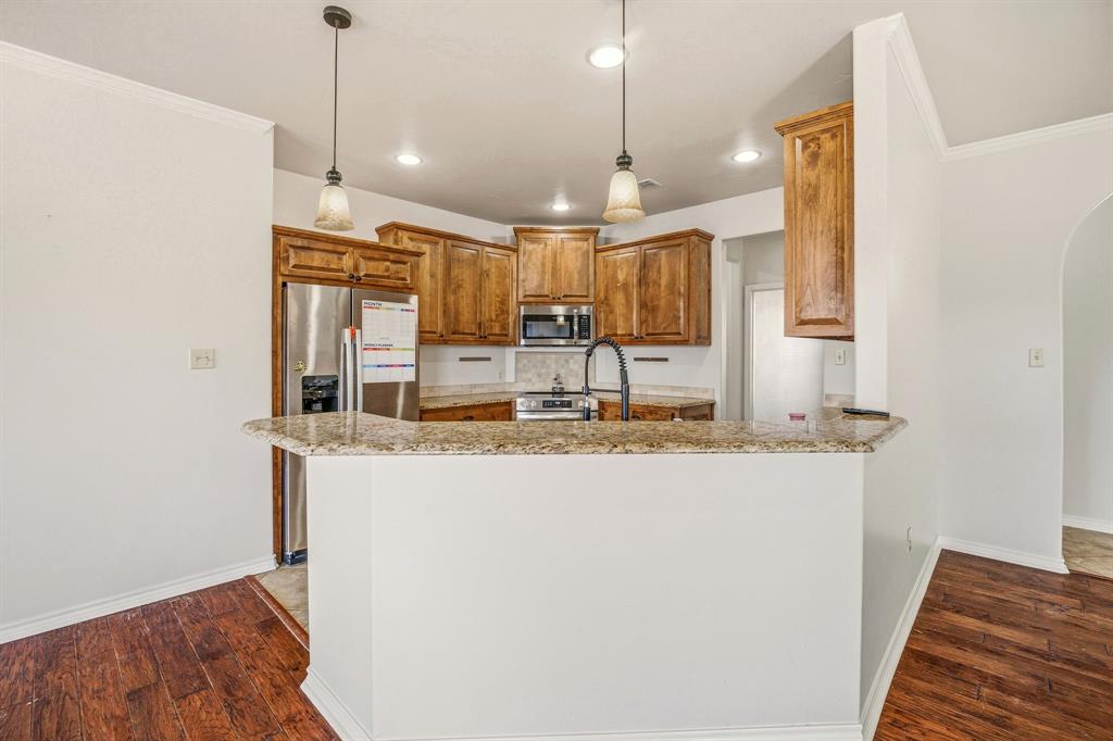 1114 Elk Ridge Drive Stephenville, TX 76401 - Photo 13 of 32 a kitchen with kitchen island a counter top space a sink and appliances