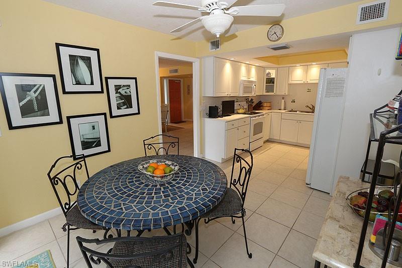 341 3rd Avenue South, Unit 341 Naples, FL 34102 - Photo 12 of 18 a kitchen with a table chairs and refrigerator
