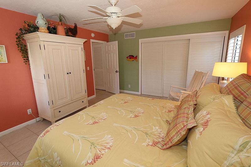341 3rd Avenue South, Unit 341 Naples, FL 34102 - Photo 14 of 18 a bedroom with a bed and a chandelier
