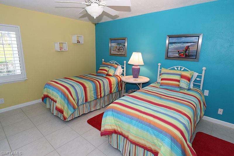 341 3rd Avenue South, Unit 341 Naples, FL 34102 - Photo 16 of 18 a bedroom with two beds and a lamp