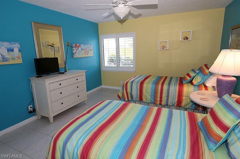 341 3rd Avenue South, Unit 341 Naples, FL 34102 - Photo 17 of 18 a bedroom with a bed and a flat screen tv