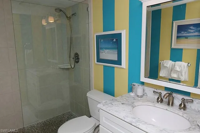 a bathroom with a granite countertop sink toilet and shower
