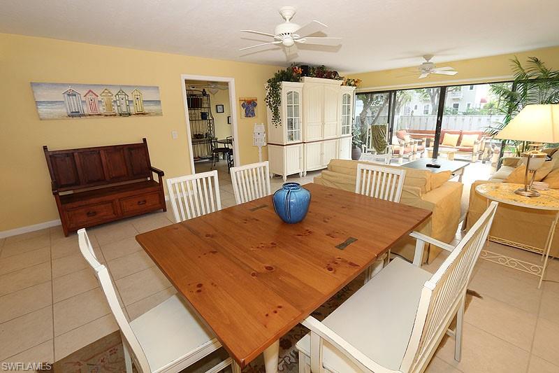 341 3rd Avenue South, Unit 341 Naples, FL 34102 - Photo 9 of 18 a view of a dining room with furniture wooden floor and chandelier