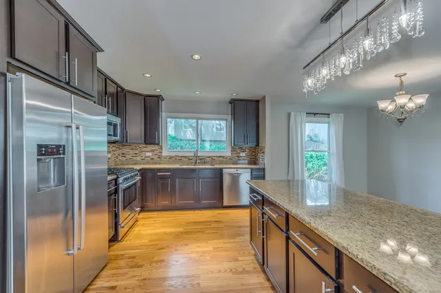 a kitchen with stainless steel appliances granite countertop a refrigerator and a sink