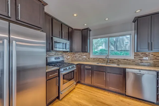 a kitchen with stainless steel appliances granite countertop a sink stove and refrigerator