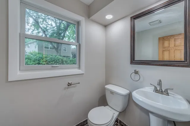 a bathroom with a toilet a sink and mirror