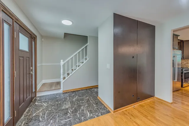 a view of an empty room with wooden floor and entryway