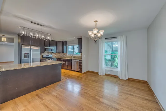 a view of kitchen with refrigerator stove and wooden floor