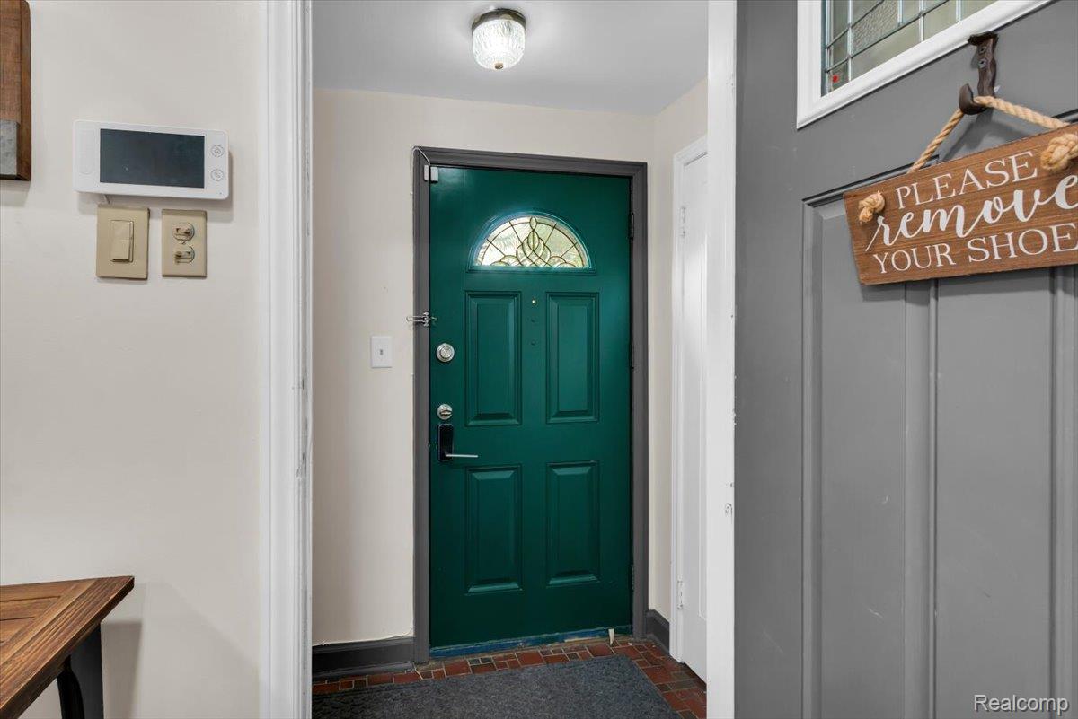 476 Touraine Road Grosse Pointe, MI 48236 - Photo 3 of 30 Entryway featuring a paneled door with an arched stained-glass insert, tiled flooring, and a flush-mount ceiling light