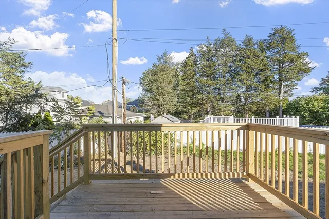 a view of a balcony with wooden floor and fence