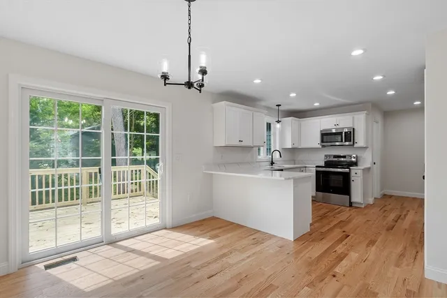 a kitchen with stainless steel appliances kitchen island granite countertop a stove top oven a sink and a chandelier