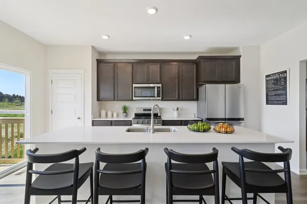 a kitchen with a dining table chairs and a refrigerator