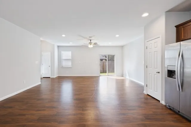 a view of a kitchen with a refrigerator and wooden floor