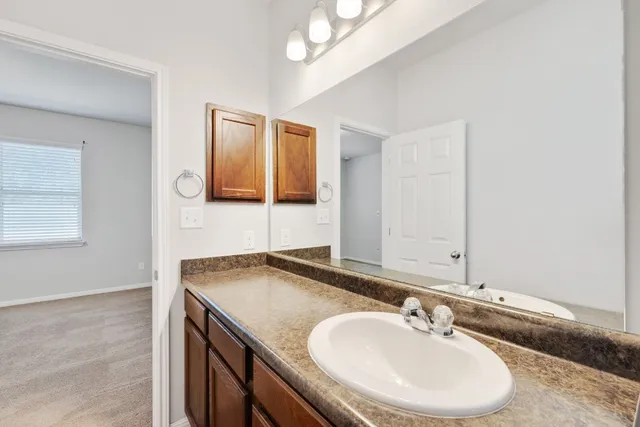 a bathroom with a granite countertop sink and a mirror