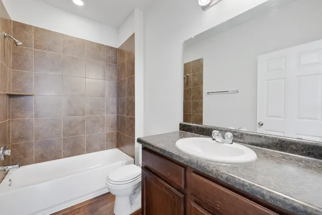 a bathroom with a granite countertop sink toilet and shower