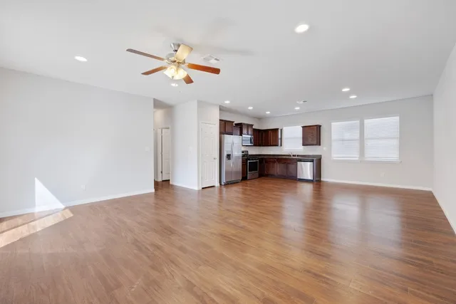 a view of a kitchen with a dishwasher cabinets a ceiling fan and wooden floor