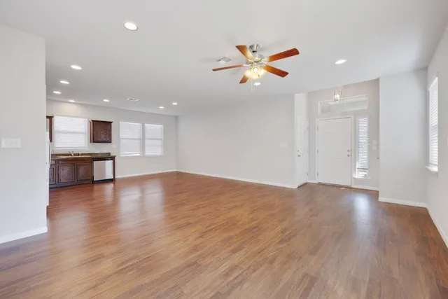 a view of empty room with wooden floor and window