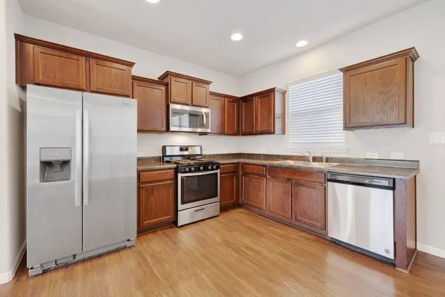 a kitchen with stainless steel appliances granite countertop a refrigerator sink and stove