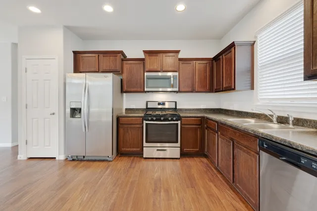 a kitchen with stainless steel appliances a refrigerator and a stove top oven