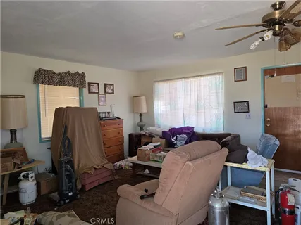 a living room with furniture a window and gym cycle