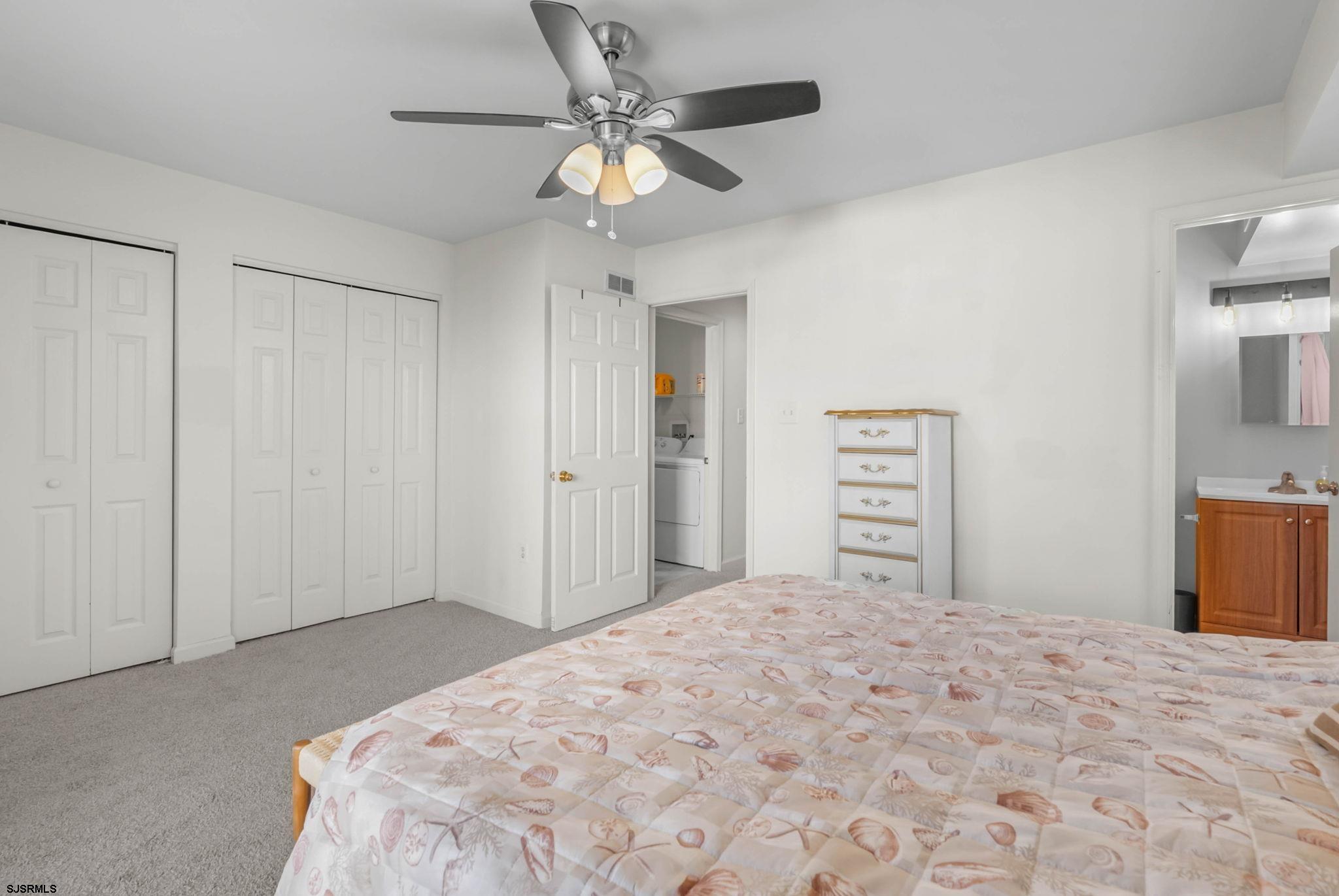 413 West Beach Avenue, Unit B Brigantine, NJ 08203 - Photo 12 of 30 a bedroom with a large bed and a chandelier