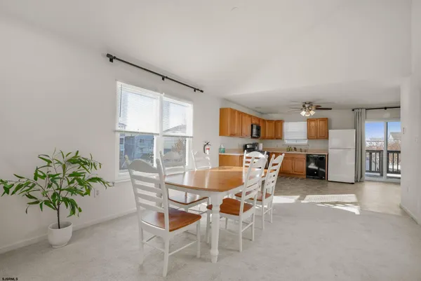 a dining room with furniture and a potted plant