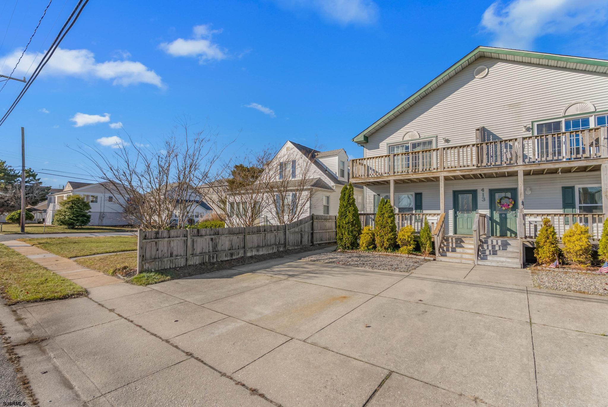 413 West Beach Avenue, Unit B Brigantine, NJ 08203 - Photo 2 of 30 a view of a white house with large windows and a small yard