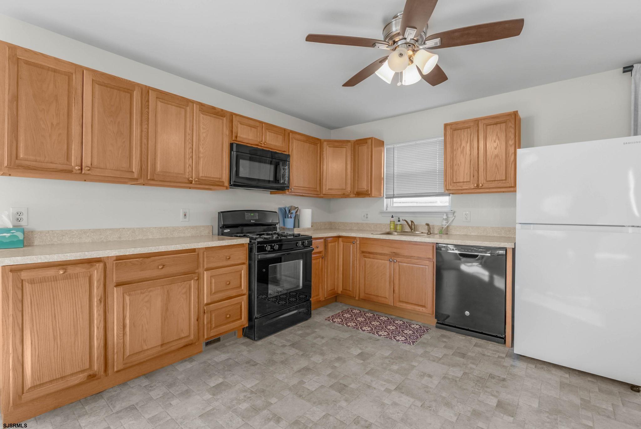 413 West Beach Avenue, Unit B Brigantine, NJ 08203 - Photo 24 of 30 a kitchen with stainless steel appliances granite countertop a refrigerator stove top oven a sink and dishwasher