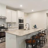 a kitchen with stainless steel appliances granite countertop a white cabinets and wooden floor
