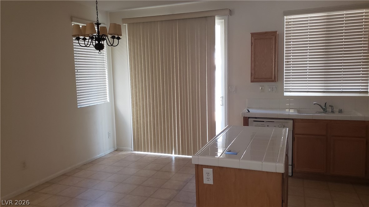 9112 Manalang Road Las Vegas, NV 89123 - Photo 36 of 50 A well-lit kitchen area features a practical tile island, offering both utility and a clear space for daily routines.