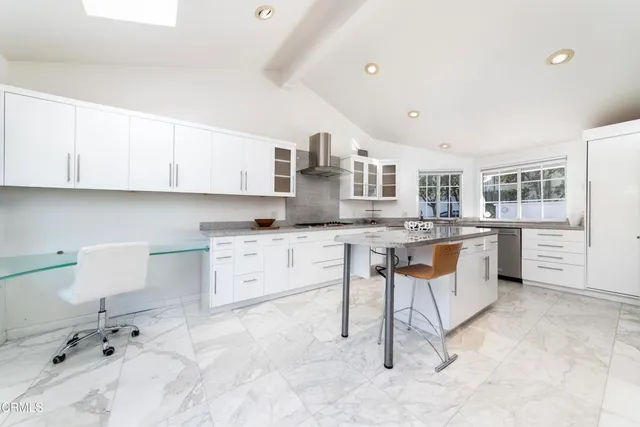 a kitchen with granite countertop a sink and white cabinets