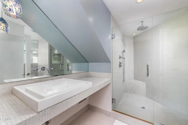 a bathroom with a sink a toilet a mirror and shower