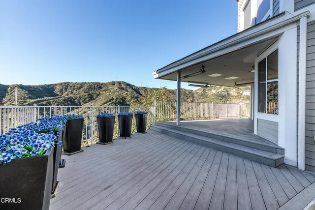 a view of a terrace with wooden floor and a yard